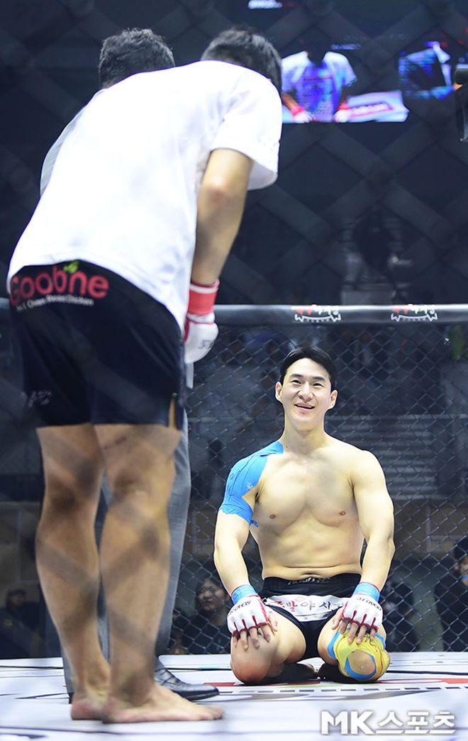 개그맨 윤형빈이 2025년 6월 서울특별시 장충체육관 로드FC 73 종합격투기 스페셜 이벤트 패배를 인정하며 무릎을 꿇은 구독자 205만 먹방 유튜버 밴쯔에게 고개와 허리를 숙여 존중을 표현하고 있다. 사진(서울 장충동)=김영구 기자