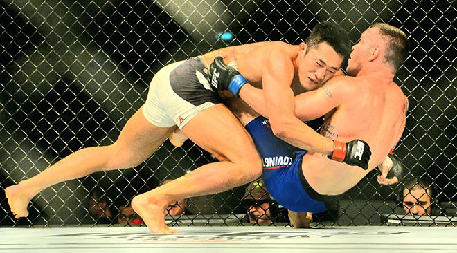 웰터급 6위 출신 김동현이 2017년 6월 싱가포르체육관 UFC 파이트 나이트 111에서 훗날 잠정 챔피언이 되는 콜비 코빙턴을 넘어뜨리고 있다. 사진=AFP=연합뉴스 제공