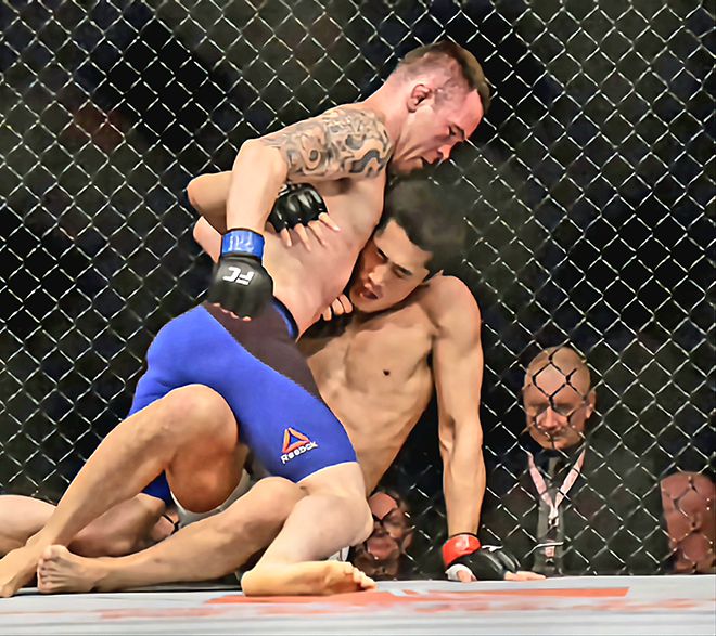 웰터급 6위 출신 김동현이 2017년 6월 싱가포르체육관 UFC 파이트 나이트 111에서 훗날 잠정 챔피언이 되는 콜비 코빙턴한테 깔려 있다. 사진=Getty Images=연합뉴스 제공