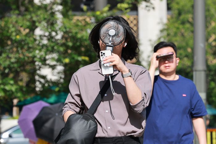 전국 대부분 지역에 폭염 특보가 발효된 10일 서울 종로구에서 휴대용 선풍기를 든 시민이 이동하고 있다. [사진 = 연합뉴스]