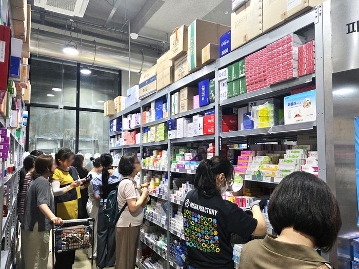 지난 3일 경기도 성남시에 위치한 메가팩토리 약국에서 방문객들이 진열대를 살펴보고 있다. 평일 낮인데도 휴대폰으로 일일이 가격을 비교하고 저렴한 제품 위주로 쓸어담는 쇼핑객들로 북적였다.  <김지희 기자>