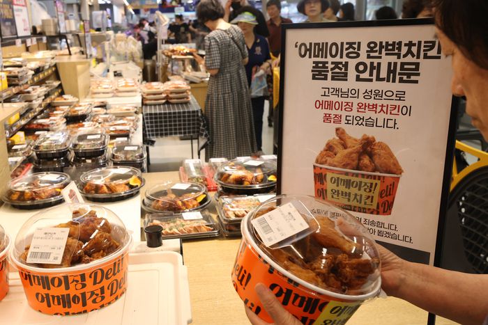 6일 서울의 한 이마트에서 시민이 치킨 구매 번호표와 치킨을 교환하고 있다. 이마트는 이날까지 100% 국내산 냉장육을 튀긴 ‘어메이징 완벽치킨’을 한 마리 3천480원(1인 1마리)에 선보인다. [사진 = 연합뉴스]