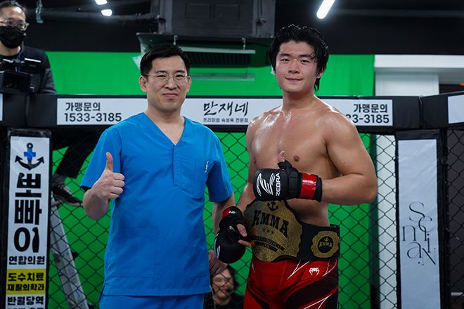 KMMA 파이터에이전시 후원사 뽀빠이연합의원 김성배 대표원장(왼쪽)이 KMMA 미들급 1차 타이틀 방어전에 성공한 권지후에게 챔피언 벨트를 감아주고 있다. 사진=스탠다드앤드프로그레스 스포츠에이전시 제공