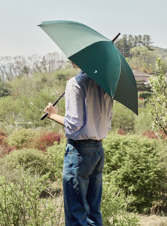 남성이 이구어퍼스트로피(29’)가 출시한 우양산 ‘매일의 우산’ 을 쓰고 있다. <무신사>
