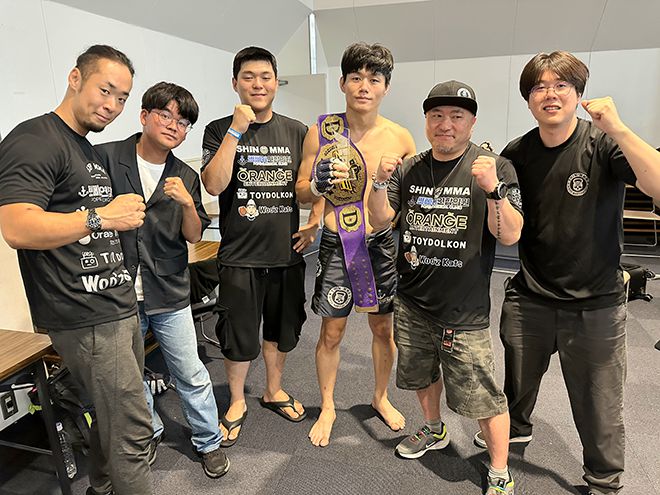 KMMA 웰터급 및 슈퍼라이트급 타이틀 도전자 출신 문홍범이 2025년 8월 일본 효고현 아마가사키시 주쇼키고센터에서 소속 체육관 신MMA 관계자들과 ACF 라이트급 챔피언 등극 기념 촬영을 하고 있다. 사진=스탠다드앤드프로그레스 스포츠에이전시 제공