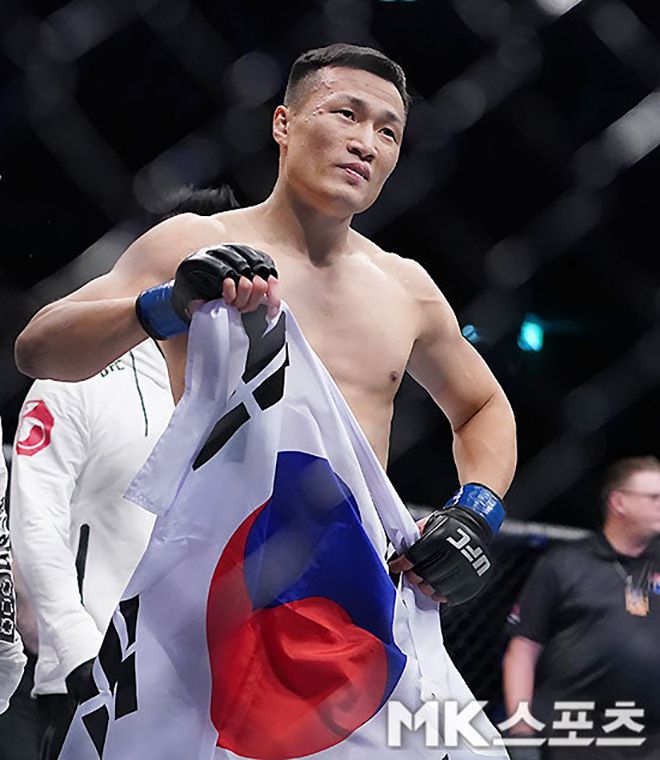 ‘코리안 좀비’ 정찬성이 2019년 12월 대한민국 부산광역시 사직실내체육관 1만651명 앞에서 제4대 UFC 라이트급 챔피언 프랭키 에드거를 1라운드 3분 18초 펀치 TKO로 꺾은 후 태극기를 펼치고 있다. 사진=김영구 기자