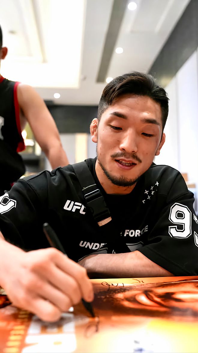 Road to UFC 시즌3 밴텀급 토너먼트 우승자 유수영이 2025년 8월 중국 상하이 현지 홍보를 위한 UFC on ESPN+ 115 포스터에 친필로 서명하고 있다. 사진=TKO
