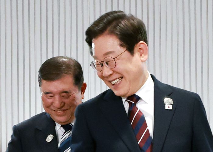 이재명 대통령이 지난 6월 17일(현지시간) 캐나다 앨버타주 카나나스키스 주요 7개국(G7) 정상회의장에서 열린 한일 정상회담에서 이시바 시게루 일본 총리와 자리를 바꾸며 밝게 웃고 있다. [김호영 기자]