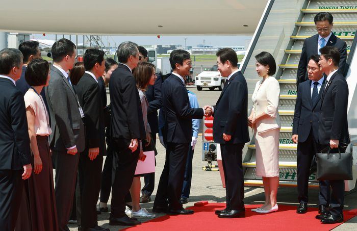 1박2일 일정으로 일본을 방문하는 이재명 대통령과 김혜경 여사가 23일 일본 도쿄 하네다공항에 도착해 환영 인사들과 인사하고 있다. [연합뉴스]