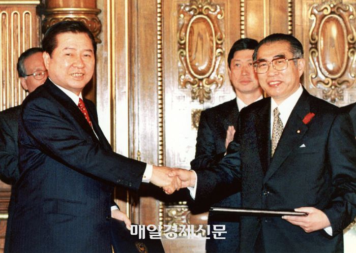 지난 1998년 10월 김대중 대통령과 오부치 게이조 일본 총리가 도쿄 영빈관에서 양국 외무장관이 지켜보는 가운데 21세기 새 시대를 위한 공동선언 협정서를 교환하며 악수하고 있다. <매일경제 DB>