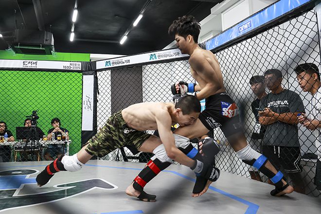 KMMA 플라이급 챔피언 문순수(왼쪽)가 도전자 김민기를 상대로 강력한 싱글레그 태클을 시도하고 있다. 사진=스탠다드앤드프로그레스 스포츠에이전시 제공