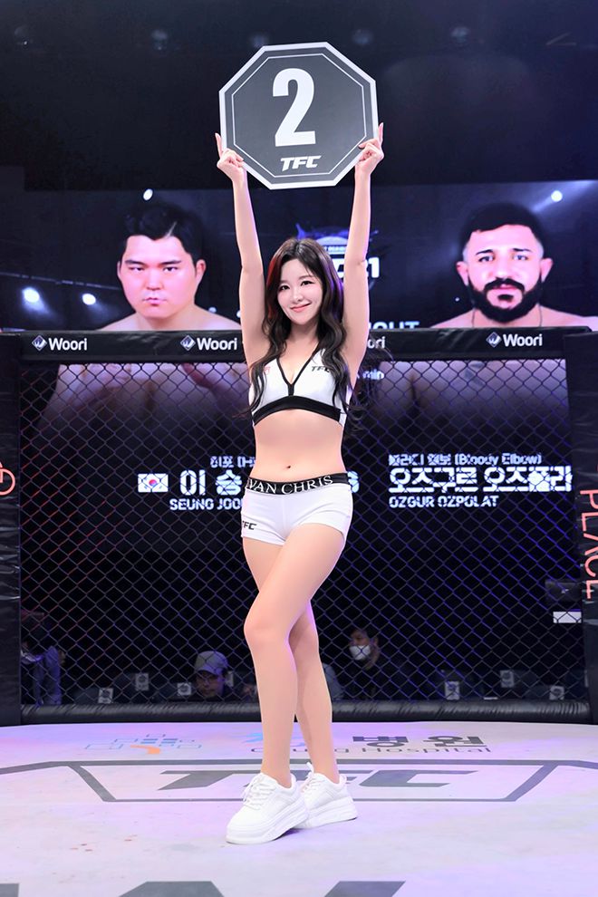 TFC걸 주현이 ‘히포’ 이승준과 Bloody Elbow 오즈포라트 오즈구르의 TFC21 메인이벤트 헤비급(120㎏) 경기 2라운드 시작을 숫자가 적힌 피켓으로 알리고 있다. 사진=Top Fighting Championship