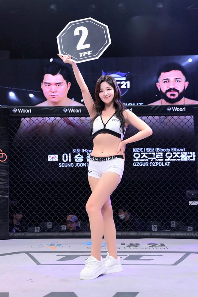 TFC걸 주현이 ‘히포’ 이승준과 Bloody Elbow 오즈포라트 오즈구르의 TFC21 메인이벤트 헤비급(120㎏) 경기 2라운드 시작을 숫자가 적힌 피켓으로 알리고 있다. 사진=Top Fighting Championship