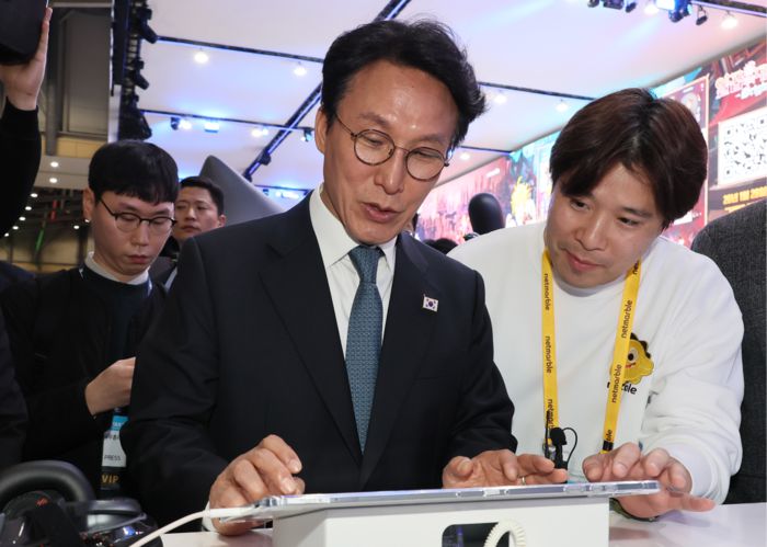 김민석 국무총리가 15일 부산 해운대구 벡스코에서 열린 ‘지스타 2025’에서 넷마블 부스를 찾아 게임을 하고 있다. [연합뉴스]