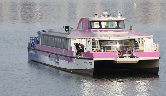 16일 서울 송파구 잠실선착장 부근 강바닥에 걸려 멈춘 한강버스에서 관계자가 수심 확인을 하고 있다. 연합뉴스