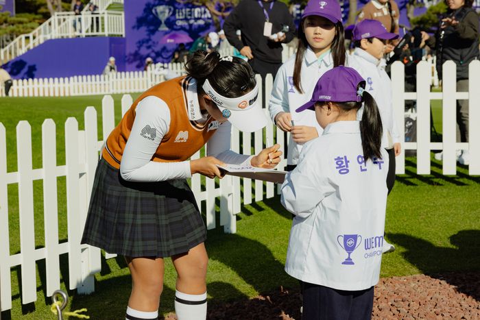 위믹스 챔피언십 첫날 위챔 키즈 황연수 어린이에게 사인을 해주고 있는 김민주. 위믹스 챔피언십