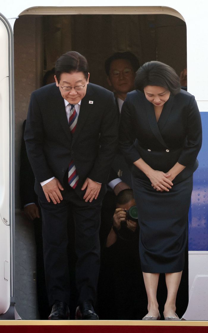주요 20개국(G20) 정상회의 참석을 계기로 아프리카·중동 4개국 순방을 마친 이재명 대통령과 김혜경 여사가 26일 성남 서울공항에 도착한 공군 1호기에서 환영객들에게 인사하고 있다. [연합뉴스]