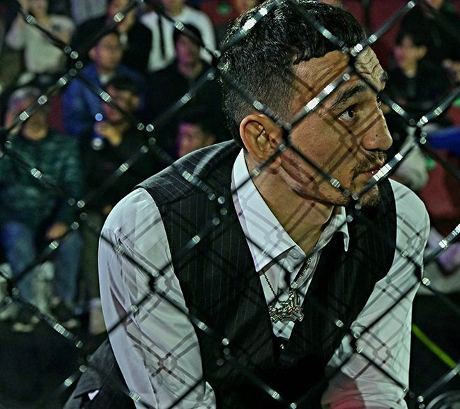 제4대 UFC 페더급 챔피언 맥스 홀러웨이가 2025년 11월 서울특별시 고려대학교 화정체육관 특설 케이지 밖에서 세컨드로 후배 제러미 산티아고가 ZFN 3 on UFC Fight Pass 제2경기 코리안좀비MMA 변재웅을 상대하는 것을 보고 있다. 사진=MCP ECC