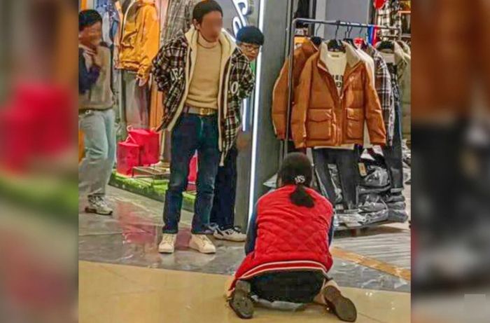 중국 중부의 한 쇼핑센터에서 여성이 무릎을 꿇고 남편에게 다운 재킷을 사달라고 애원하는 영상이 소셜미디어에서 빠르게 확산하면서 이 남성에 대한 비난이 쏟아지고 있다. [사진출처 = SCMP]