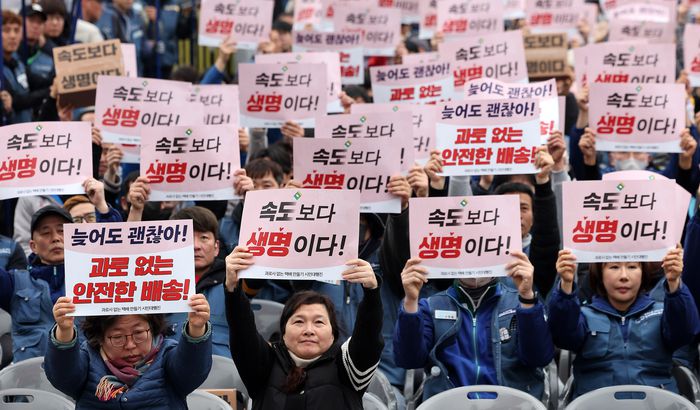택배노동자들이 지난달 23일 서울 광화문 동십자각 앞에서 열린 ‘과로사 없는 택배 만들기 시민대행진’에 앞서 구호를 외치고 있다. [뉴스1]