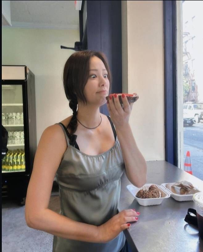 손태영은 올리브색 나시 탑을 블랙 나시 위에 레이어드한 스타일을 선보이며, 가볍고 편안한 무드의 데일리 패션을 연출했다.사진=손태영 SNS