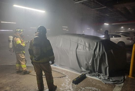 불난 전기차 질식소화포로 덮은 소방대원들 (충남 아산소방서 제공)