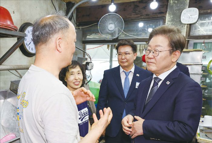 이재명 대통령이 경기도지사 시절 설계한 연천군 농촌기본소득 실행 현장을 방문해 정책 효과를 경청하고 있다.  (연합뉴스)