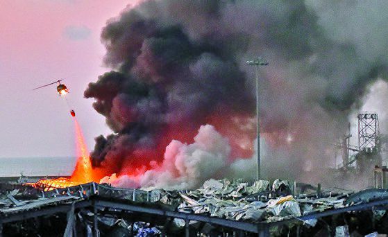 대형 폭발이 발생한 레바논 베이루트 현장에서 헬리콥터가 물을 뿌리며 진화하고 있다. [AFP= 연합뉴스]