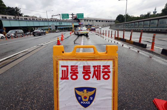 수도권 일대 집중호우로 한강 수위가 높아진 3일 오후 서울 서초구 동작대교 남단에서 경찰이 김포공항 방면 올림픽대로 통행을 통제하고 있다. 연합뉴스