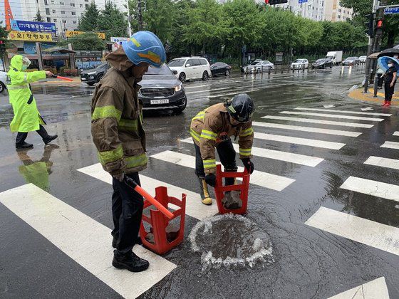 7일 대구 지역에 내린 집중 호우로 대구 북구 읍내동 도로 맨홀에서 물이 역류하고 있다. [사진 대구소방안전본부]