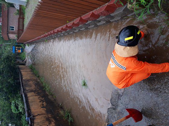 경북 칠곡군 한 주택 마당이 침수돼 배수 작업을 하고 있다. [사진 경북소방본부]