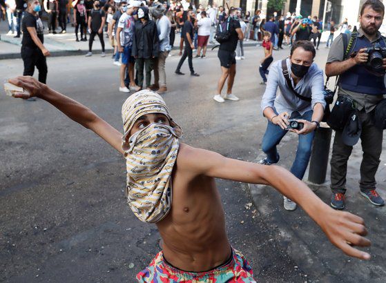10일 레바논 반정부 시위 현장에서 한 시위 참가자가 돌을 던지려고 하고 있다. [로이터=연합뉴스]