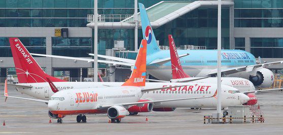 제주항공이 이스타항공과의 노딜을 선언한 다음 날인 지난달 24일 오전 인천국제공항 주기장에 제주항공과 이스타항공 소속 여객기가 각각 세워져 있다. 연합뉴스