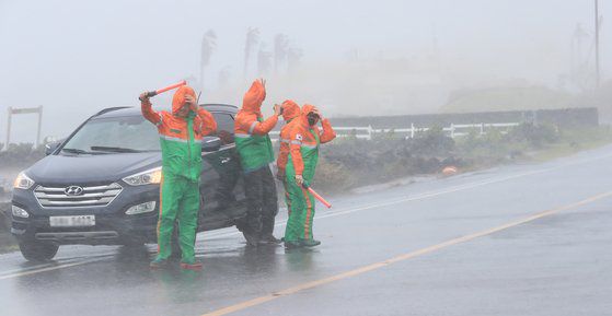 26일 오후 제주도 자율방재단원들이 침수된 제주 서귀포시 대정읍 상모리 해안도로 구간에서 차량 진입을 통제하고 있다. [연합뉴스]