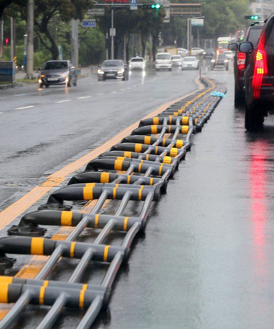 제8호 태풍 '바비'가 제주를 강타한 26일 오전 제주시 남녕고등학교 교차로 인근 도로 중앙분리대가 엿가락처럼 휘어 쓰러져 있다. [연합뉴스]