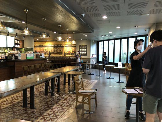 여의도의 한 스타벅스에서 점원이 들어오는 고객마다 체온을 확인하고 명단을 작성하고 있다. 배정원 기자