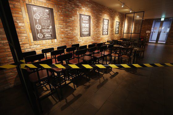 '사회적 거리두기 2.5단계'가 실시되며 수도권 프렌차이즈 커피 전문점 매장 내 이용이 금지된 지난달 30일 오후 서울 중구 스타벅스 한국프레스센터점에 좌석 이용 통제선이 설치돼있다.   연합뉴스