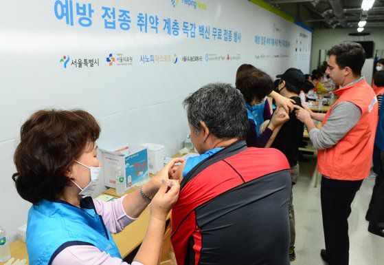 지난해 10월 24일 오전 서울 용산구 동자동 따스한 채움터에서 인근 노숙인과 쪽방촌 주민들이 사노피 파스퇴르 등의 지원으로 무료 독감 예방접종을 받고 있다.연합뉴스