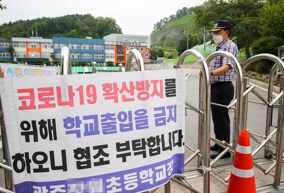 지난 7월 2일 등교 중지 결정이 내려진 광주광역시 동구의 한 초등학교 정문을 학교 관계자가 닫고 있다. 프리랜서 장정필