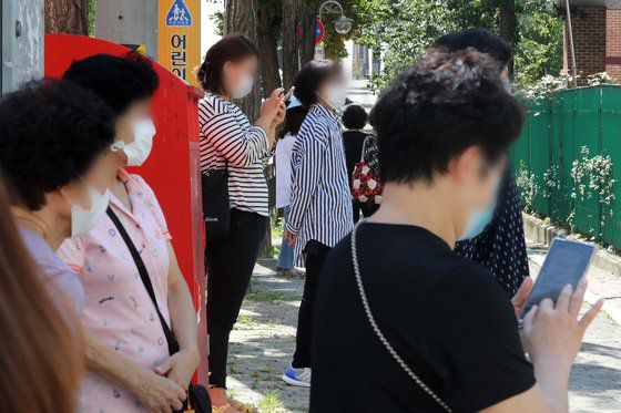 수도권의 유치원과 초·중·고등학교 등교가 재개된 21일 오전 서울 강동구 한산초등학교 교문 앞에서 학부모들이 수업을 마친 학생들을 기다리고 있다. 뉴스1