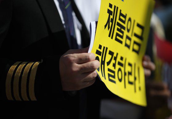 22일 오전 서울 여의도 국회 앞에서 열린 '이스타항공 노동자 고용유지 촉구를 위한 조종사 노동조합 합동 기자회견'에서 참가자들이 손팻말을 들고 있다. 연합뉴스