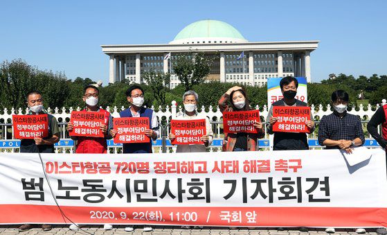 22일 오전 서울 여의도 국회 앞에서 열린 '이스타항공 정리해고 사태 해결 촉구 범 노동시민사회 기자회견'에서 참가자들이 손팻말을 들고 있다. 연합뉴스