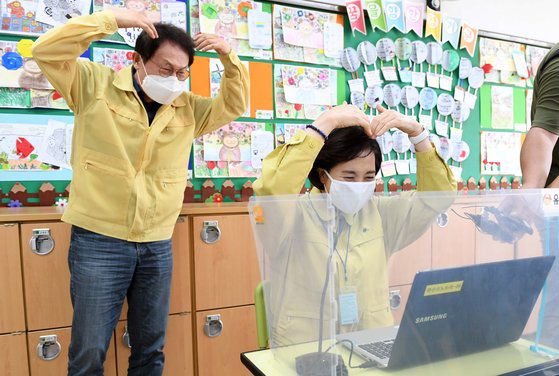 유은혜 사회부총리 겸 교육부 장관(오른쪽)과 조희연 서울시교육감이 수도권 등교 지난달 21일 오전 서울 강동구 한산초등학교를 방문해 4학년 학생들과 원격수업으로 인사하고 있다. 연합뉴스