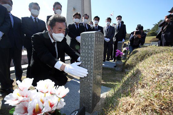 이낙연 더불어민주당 대표가 24일 민주묘지에서 참배를 마친 뒤 윤상원 열사 묘비를 찾아 ″광주 희생자들이 멀리 있는 게 아니라 가까운 곳에 있다는 상징″이라고 말했다. [뉴스1]