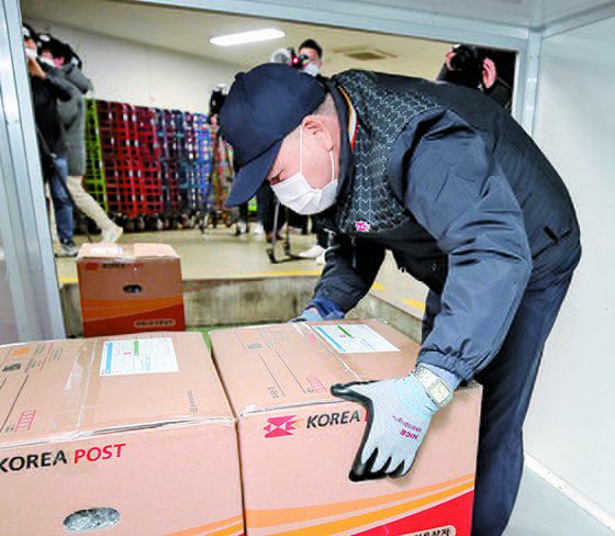 23일 오전 서울 중구 서울중앙우체국 발착장에서 한 집배원이 구멍 손잡이 소포상자를 택배차량에 싣고 있다. 소포상자 구멍 손잡이는 운반편의를 위해 만들었다. [뉴시스]