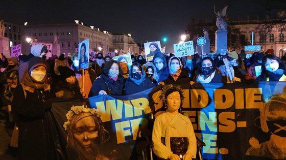 지난 25일(현지시간) 세계 여성폭력 추방의 날을 맞아 열린 도심 집회에 참가한 시위대와 베를린 미테구에 설치된 평화의 소녀상. [연합뉴스]