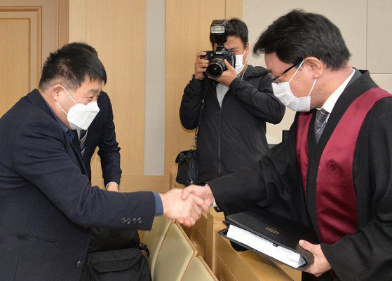재심 청구인 윤성여 씨가 무죄를 선고받고 검사와 악수하고 있다. 뉴스1