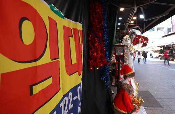 18일 서울 중구 남대문시장의 한 점포 앞에 임대 문의 현수막이 걸려 있다. 바로 옆 점포에서는 성탄절 장식품을 판매하고 있다. 연합뉴스