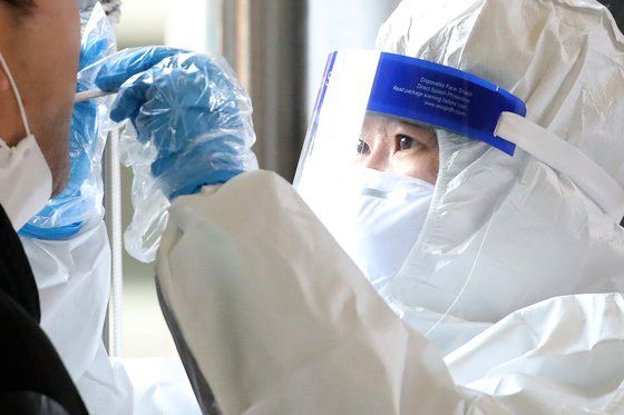 25일 오후 대구 동구보건소에 마련된 선별진료소에서 의료진이 크리스마스도 잊은 채 신종 코로나바이러스 감염증(코로나19) 진단검사를 위해 방문한 시민의 검체를 채취하고 있다. 뉴스1