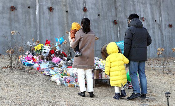 정인이가 안치된 경기도 양평의 ‘하이패밀리 안데르센 공원묘지’에서 5일 오후 추모객들이 놓고 간 꽃과 선물들을 한 가족이 바라보고 있다. 뉴스1